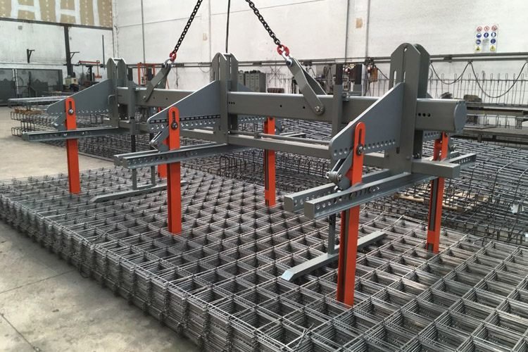 Crane-mounted mesh lifting beam raising stacked weldmesh panels flat inside the plant