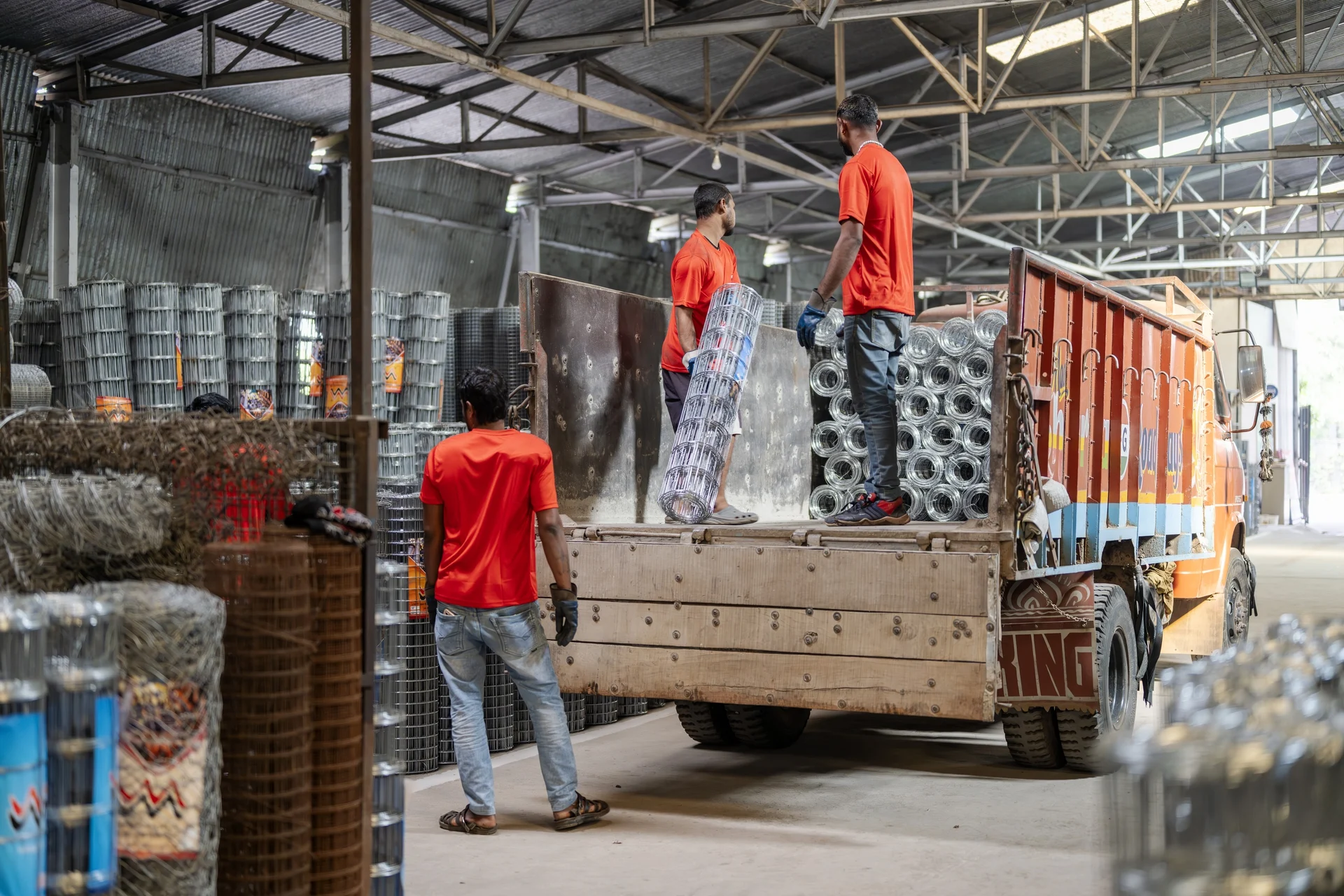 Workers loading GI weldmesh rolls onto a truck for dispatch